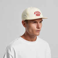 A man wearing a cream-colored snapback cap with a red 'ARENA' logo on the front, paired with a white t-shirt, against a plain light gray background.