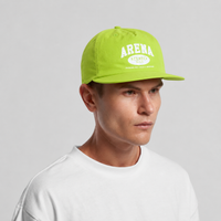 A man wearing a citrus green flat-brim cap with 'ARENA STEREO' printed in white on the front, paired with a white crewneck t-shirt, set against a plain light gray background.
