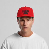 A man wearing a bright red snapback cap with 'ARENA' printed in black on the front, paired with a white crewneck t-shirt against a light gray background.