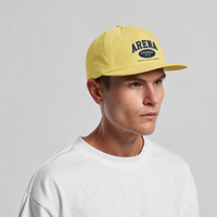 A man wearing a yellow baseball cap with a navy blue 'ARENA STERO' logo on the front, paired with a white t-shirt against a light gray background.
