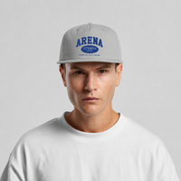 A man wearing a light gray snapback cap with blue 'ARENA' embroidery, paired with a white crewneck t-shirt, against a light gray background.