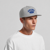 A man wearing a light gray snapback cap with blue 'ARENA STEREO' text on the front, paired with a white crewneck sweatshirt, against a light gray studio background.