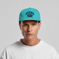 A man wearing a bright turquoise blue snapback cap with 'ARENA STEREO 501' printed in dark blue on the front, paired with a white crewneck t-shirt against a light gray background.
