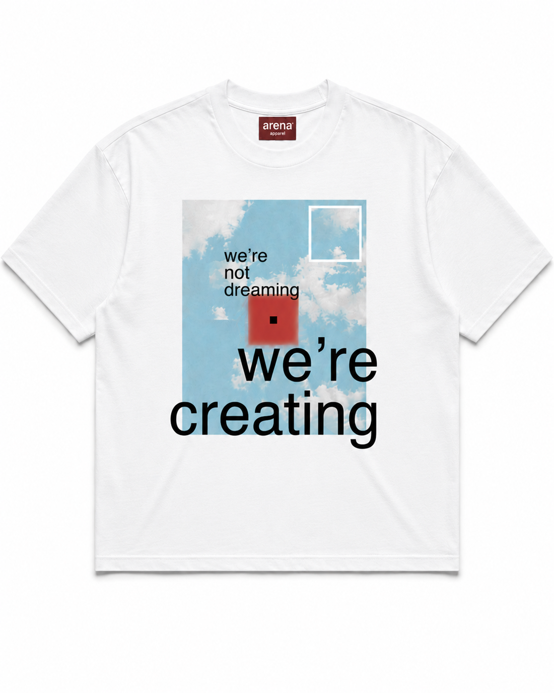 A white crewneck t-shirt featuring a graphic print on the front. The graphic depicts a light blue sky with white clouds, a red square, and black text reading 'we're not dreaming we're creating'.
