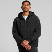 A man wearing a black zip-up hoodie with red embroidered text on the left chest, photographed against a plain light gray studio background.